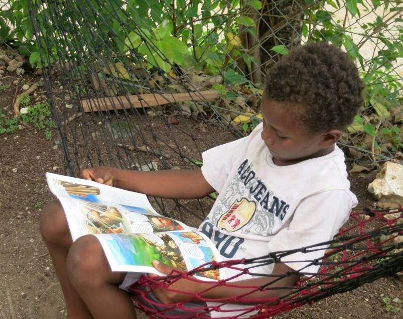 10-year-old Timmy enjoys reading a Bible Comic in his language, Arosi.